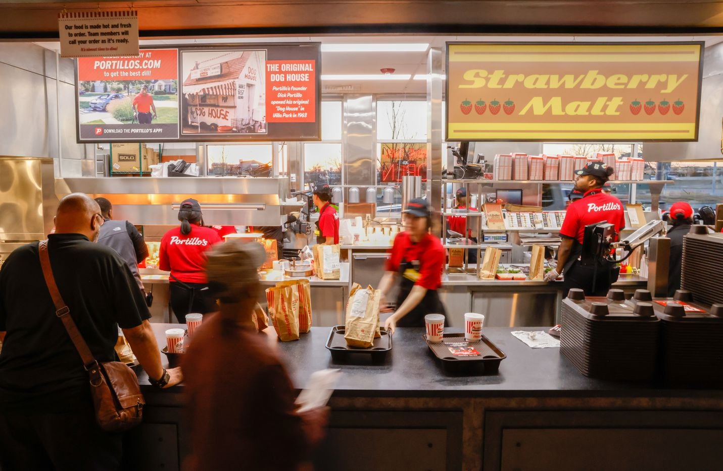 Crew members move through the kitchen of Portillo’s on its opening day in The Colony on...