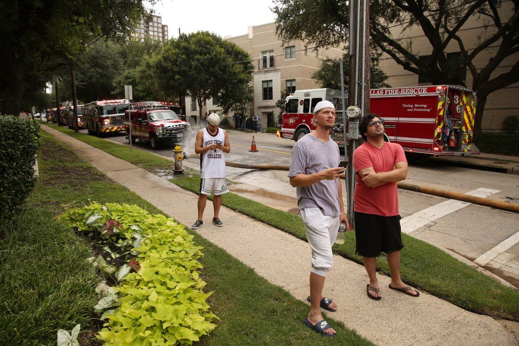 Onlookers gathered outside an Uptown apartment complex  as Dallas Fire-Rescue put out a fire...