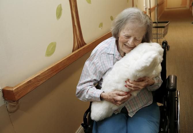 
Dorothy Hartley, 89, hugs a robotic pet named Paro at a retirement community in Cupertino,...