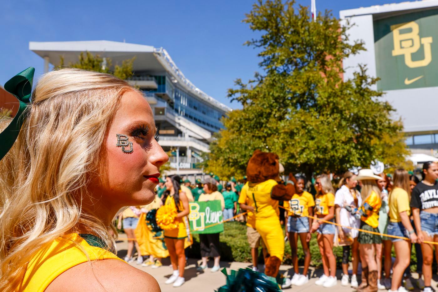 A Baylor cheerleader stands with fans during the Bear Walk before an NCAA football game...
