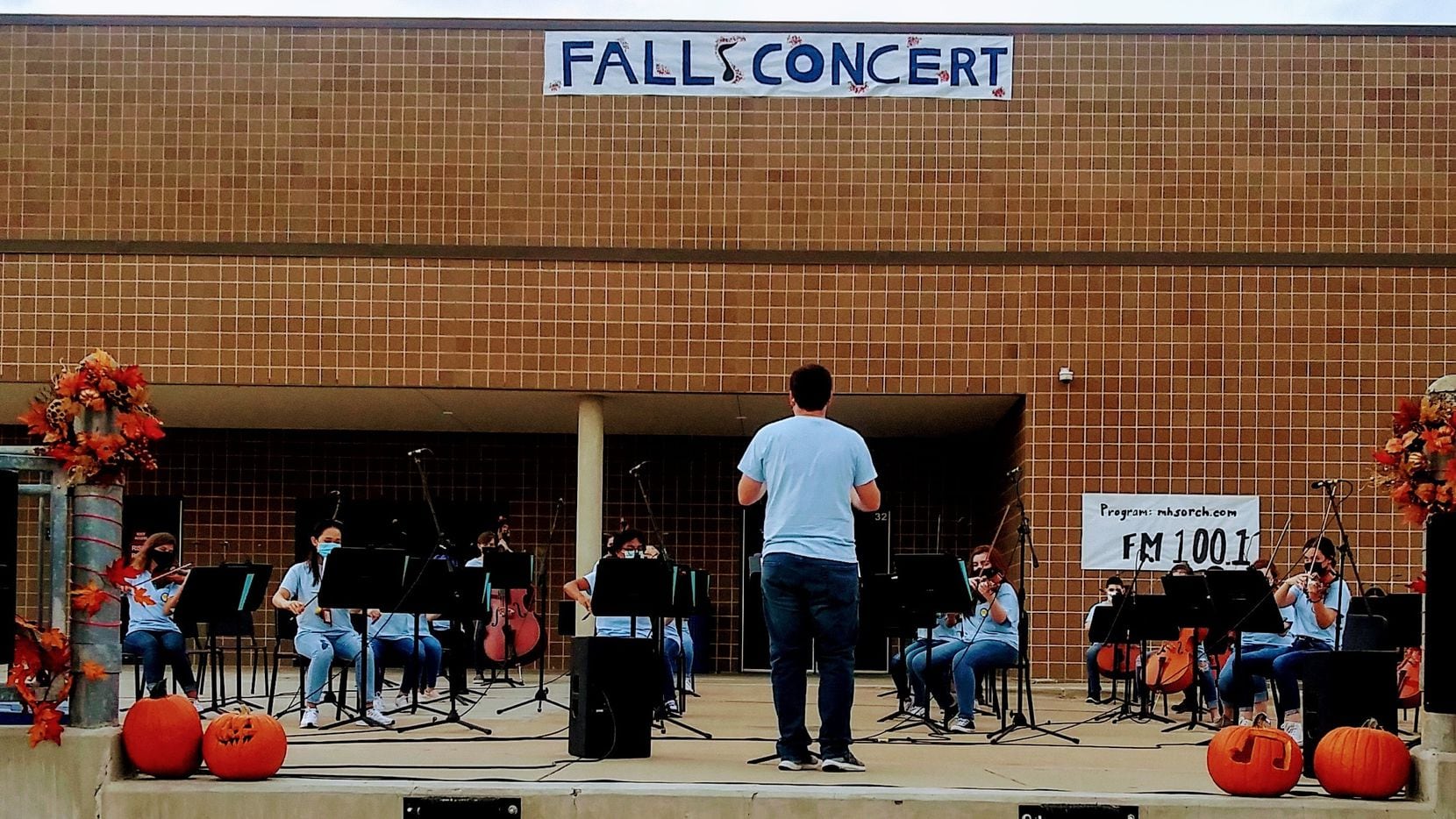 McKinney High School orchestra members perform on the school's loading dock during a concert...