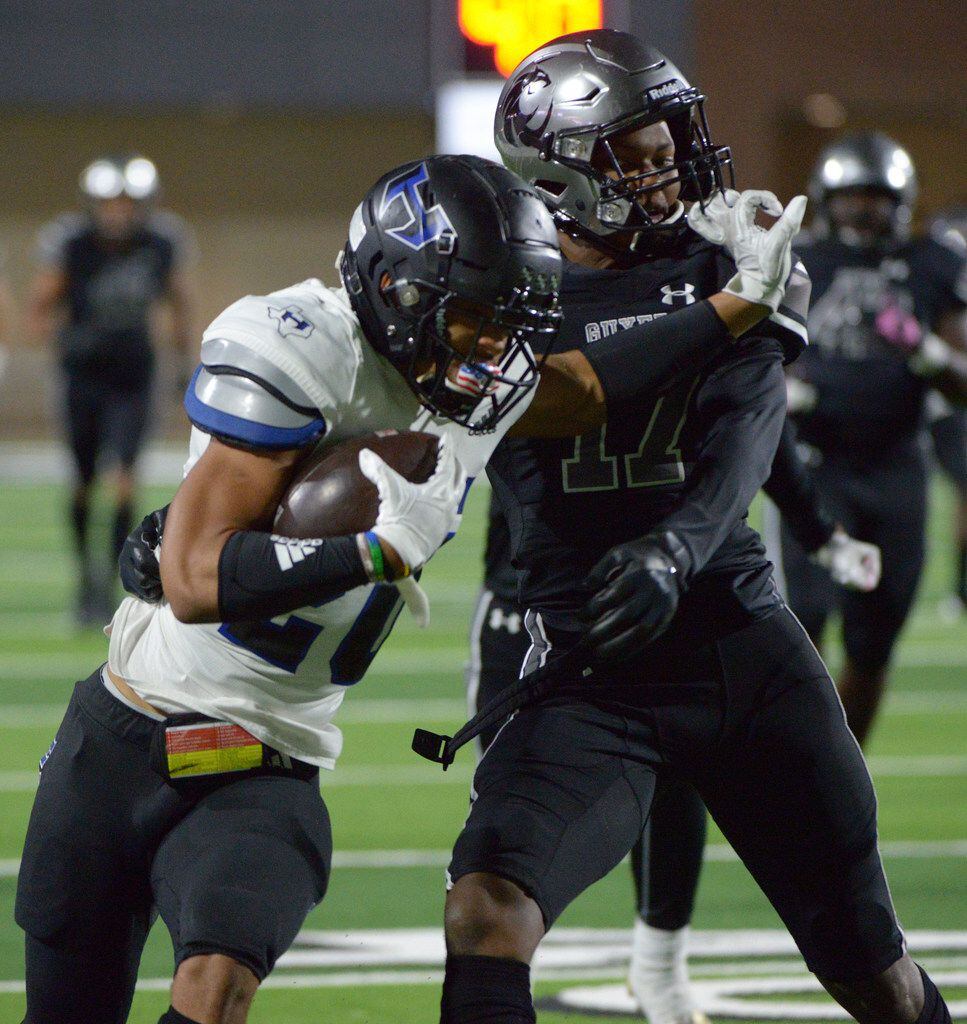 Hebron's Isaiah Broadway (20) tries to get away from a tackle attempt by Guyer's Jaden...