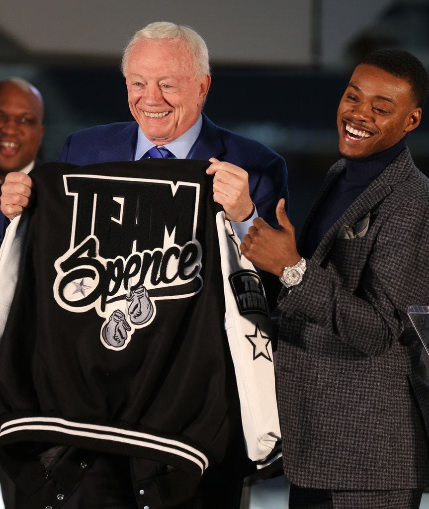 Errol Spence Jr. gives Dallas Cowboys owner Jerry Jones his team letterman jacket during a...