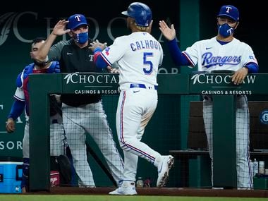 Texas Rangers designated hitter Willie Calhoun celebrates with Texas Rangers manager Chris Woodward and bench coach Don Wakamatsu after scoring during the eighth inning against the Boston Red Sox at Globe Life Field on Saturday, May 1, 2021.