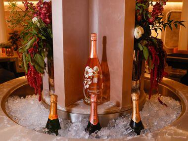 A round ice trough chills champagne in the center the bar of Coupes in Dallas on Friday,...
