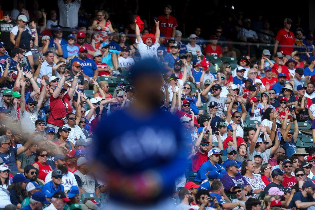 Texas Rangers fans do the wave as center fielder Delino DeShields (3) steps up to bat during...