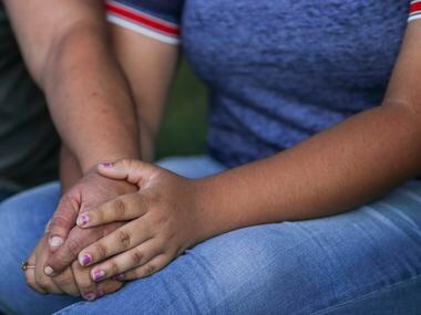 Christina Lopez, left, reaches over to comfort her daughter, Celia Lopez, 15, who was...