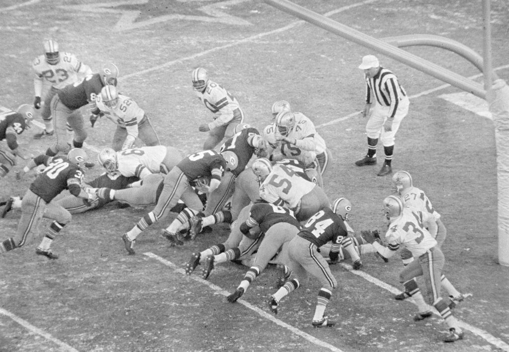In this Dec. 31, 1967, file photo, Green Bay Packers quarterback Bart Starr (15), follows his blockers including Jerry Kramer (64) against the Dallas Cowboys, including Jethro Pugh (75) for a touchdown, in the Ice Bowl in Green Bay, Wisc.
