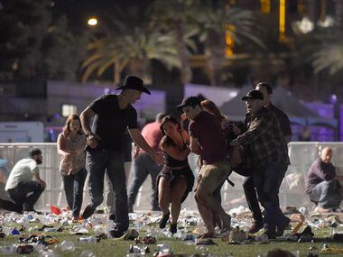 People carry a victim at the Route 91 Harvest country music festival after gunfire was heard...