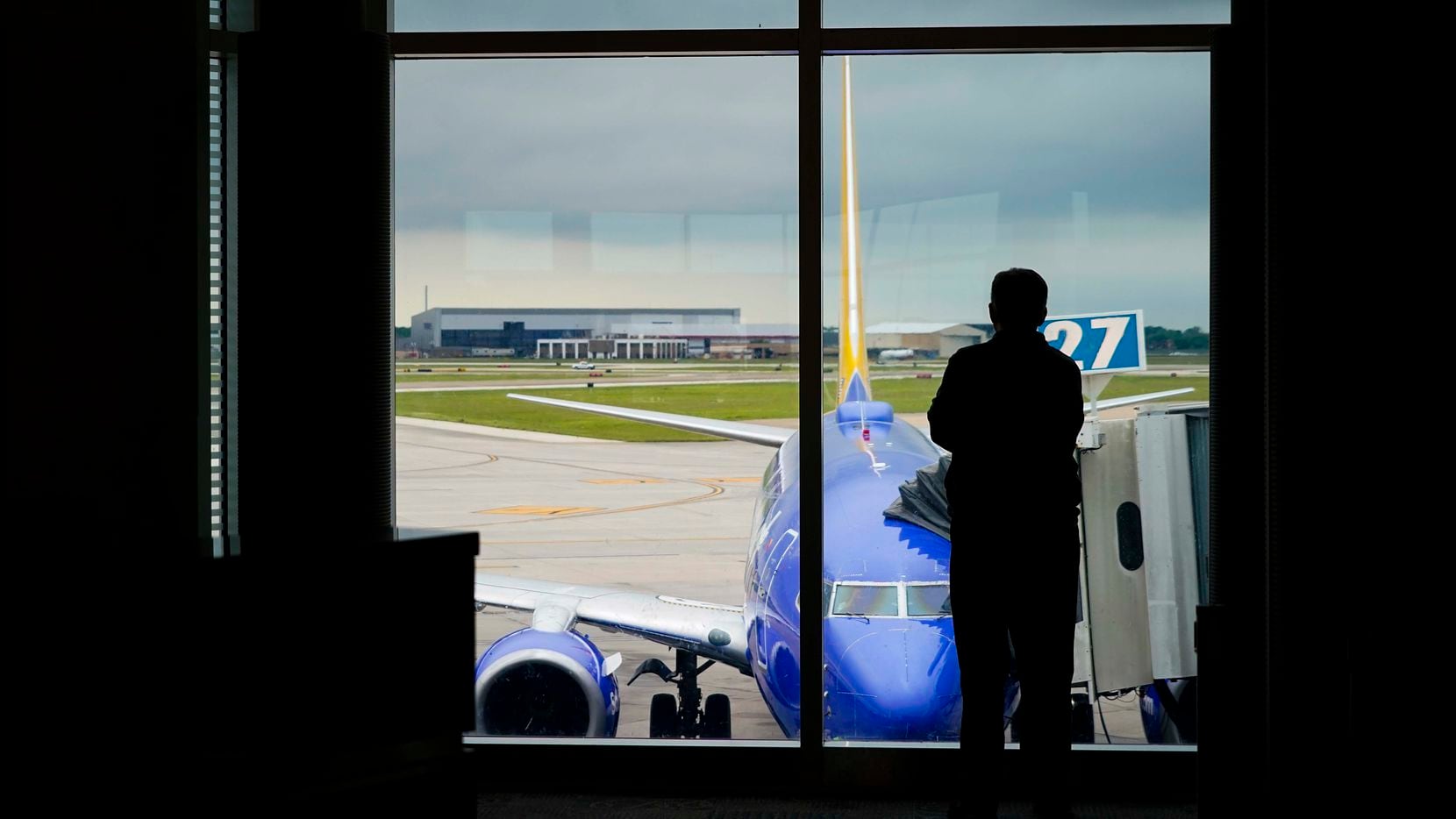 A man looks out over a Southwest Airlines 737 parked at a gate at Houston Hobby Airport on...
