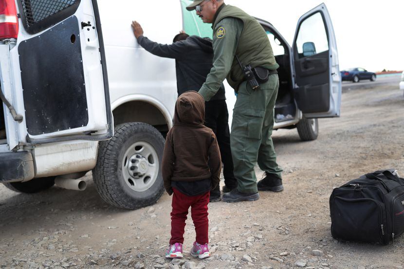 Un niño observa cuando un agente de la Patrulla Fronteriza arresta a un inmigrante adulto en...