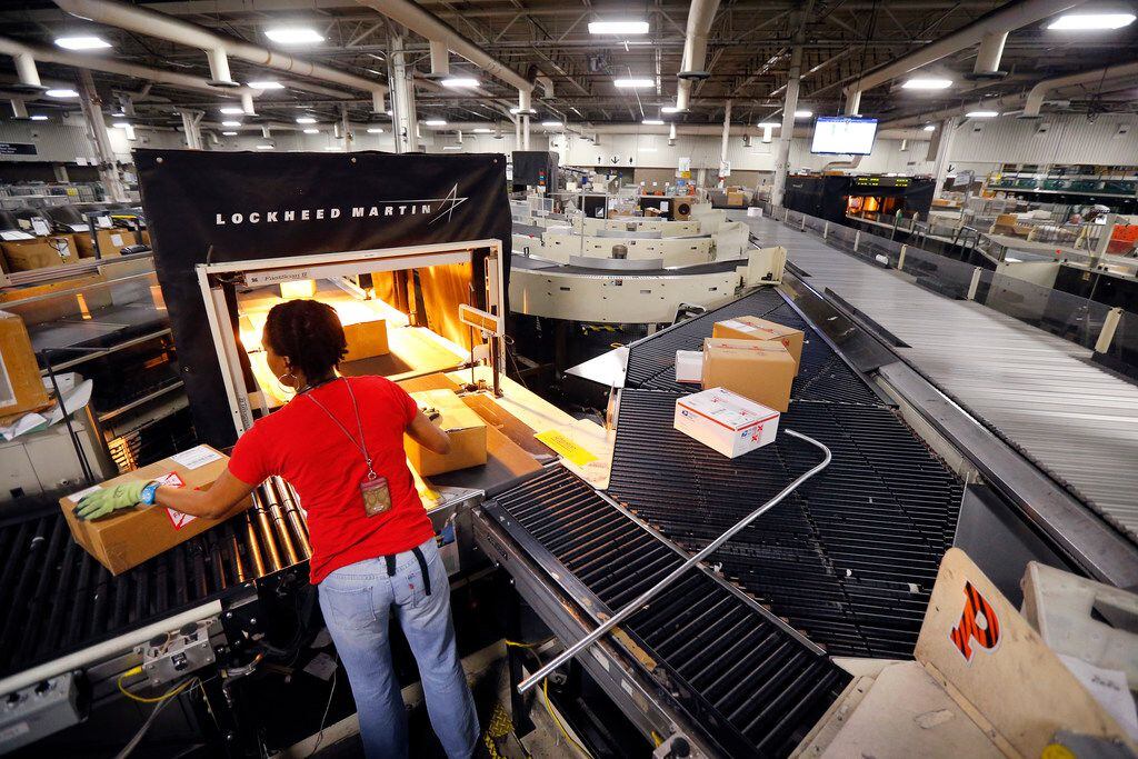 Mail handler Ronda Cash catches left over parcels that have to be reoriented and scanned on...