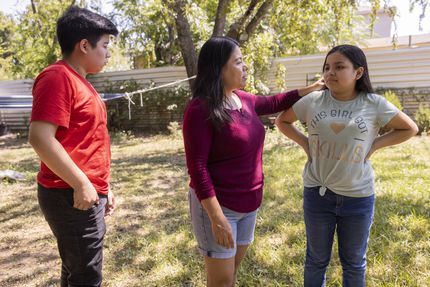 Ernesto Núñez, de 12 años, observa a su madre Yolanda Mendoza acariciando a su hermana...