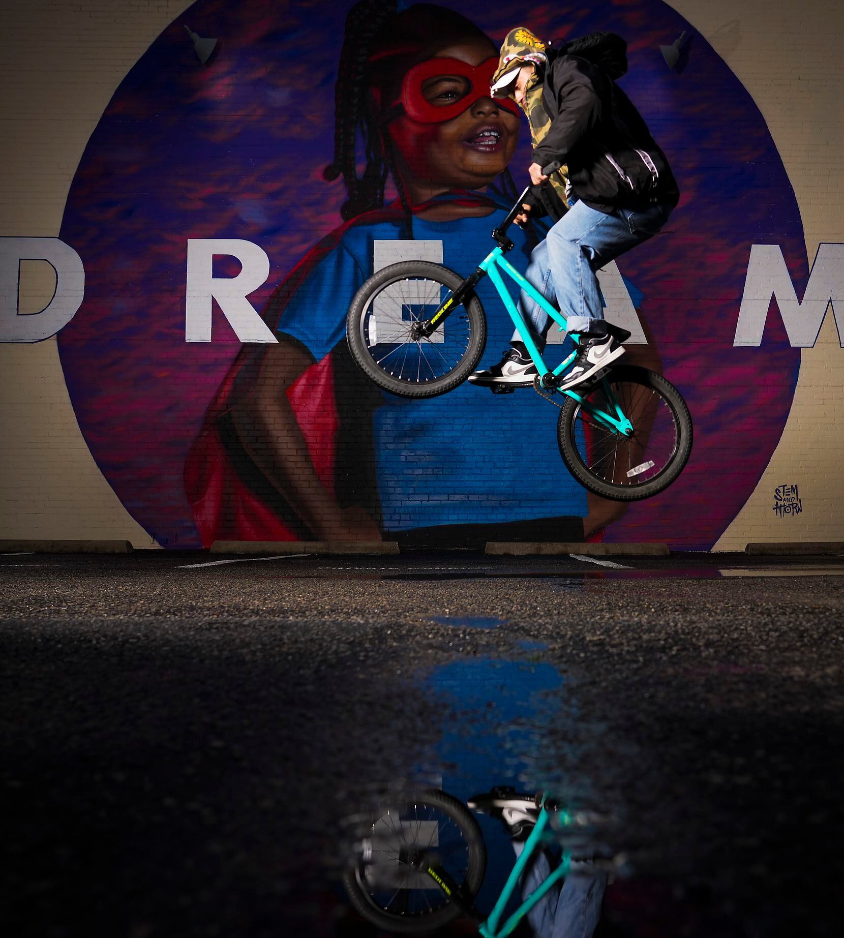 Jorge Torres performs a bike stunt near his Real Street Jams shop in Deep Ellum. The brand...