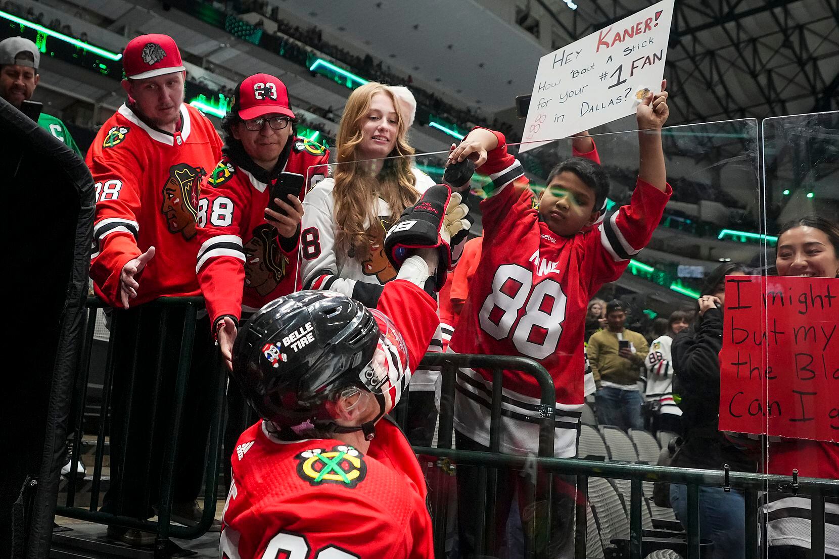 Chicago Blackhawks right wing Patrick Kane (88) gives a puck to a fan before an NHL hockey...