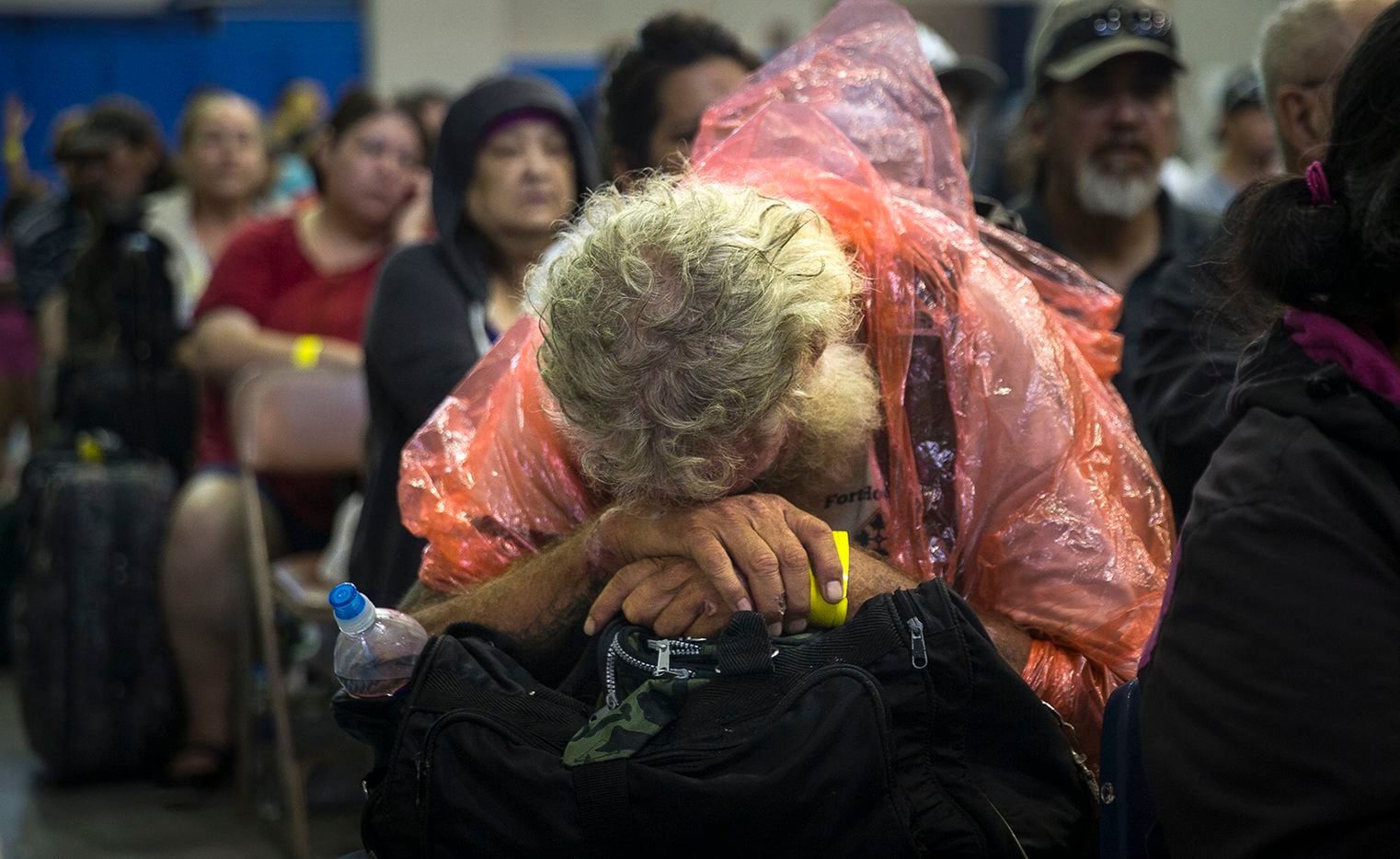A man rests while waiting to board a bus headed for San Antonio at an evacuation center in...