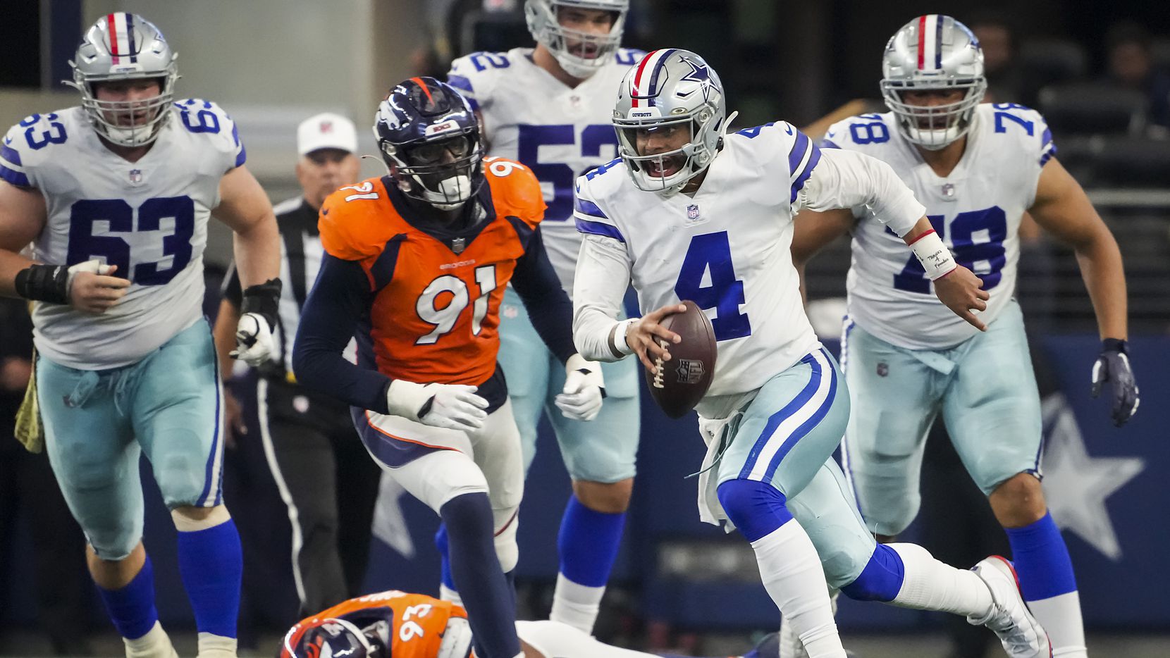 Dallas Cowboys quarterback Dak Prescott (4) scrambles for a first down past Denver Broncos...