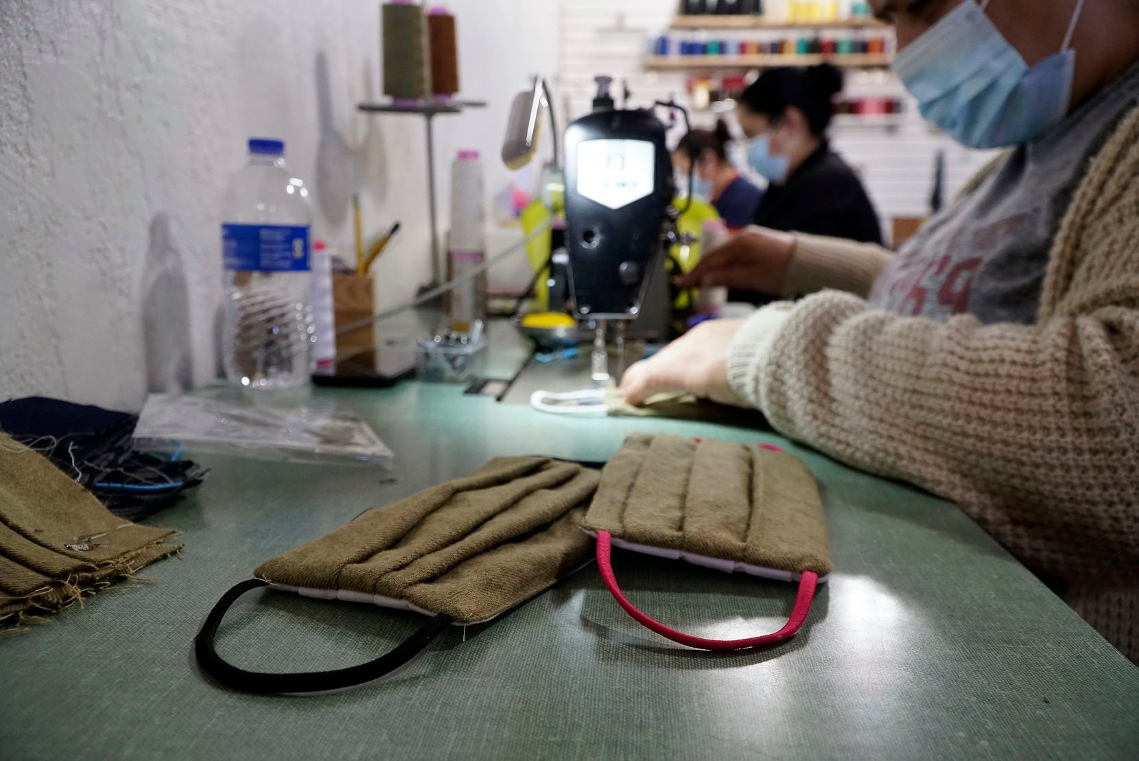 A seamstress sews a mask in fashion designer Julie McCullough's studio. McCullough is also...