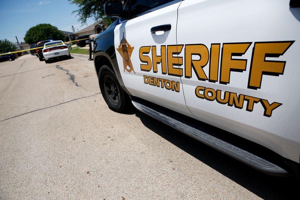 Denton County Sheriff's officers investigate a crime scene at a home where five people were...