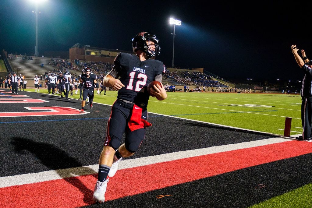Coppell quarterback  Kevin Shuman (12) celebrates after scoring on a touchdown run during...