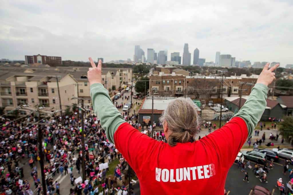 Herb Keener waves to participants reaching the end of the Dallas Women's March from atop the...