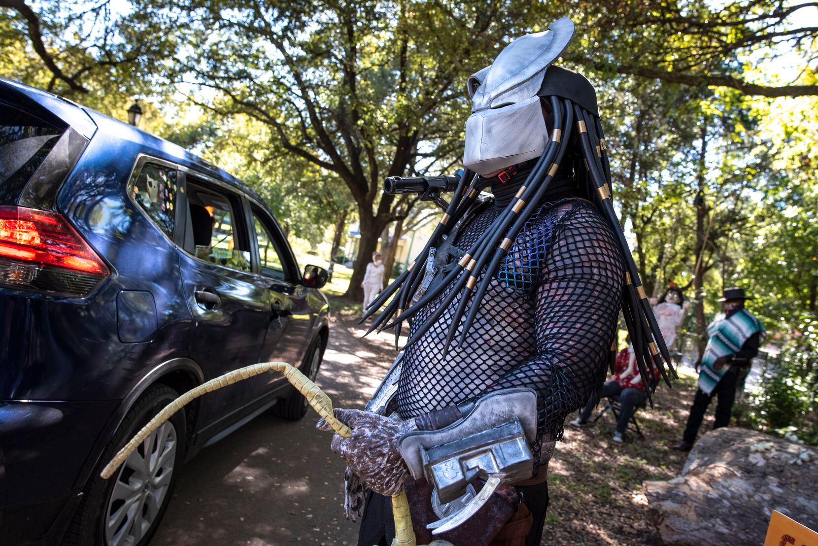 Mayor Pro-Tem Adam Medrano sports a Predator costume while greeting families as they drive-through the contactless Candy Caravan event hosted by The City of Dallas at Dallas Heritage Village, on Saturday, Oct. 31, 2020.