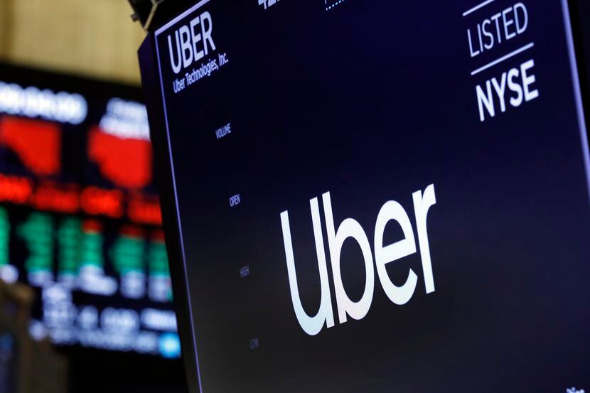 FILE - In this Aug. 9, 2019, file photo, the logo for Uber appears above a trading post on...