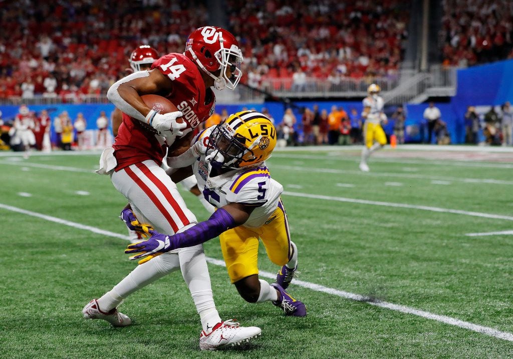 ATLANTA, GEORGIA - DECEMBER 28: Wide receiver Charleston Rambo #14 of the Oklahoma Sooners is tackled by cornerback Woodi Washington #5 of the Oklahoma Sooners during the Chick-fil-A Peach Bowl at Mercedes-Benz Stadium on December 28, 2019 in Atlanta, Georgia. (Photo by Kevin C. Cox/Getty Images)