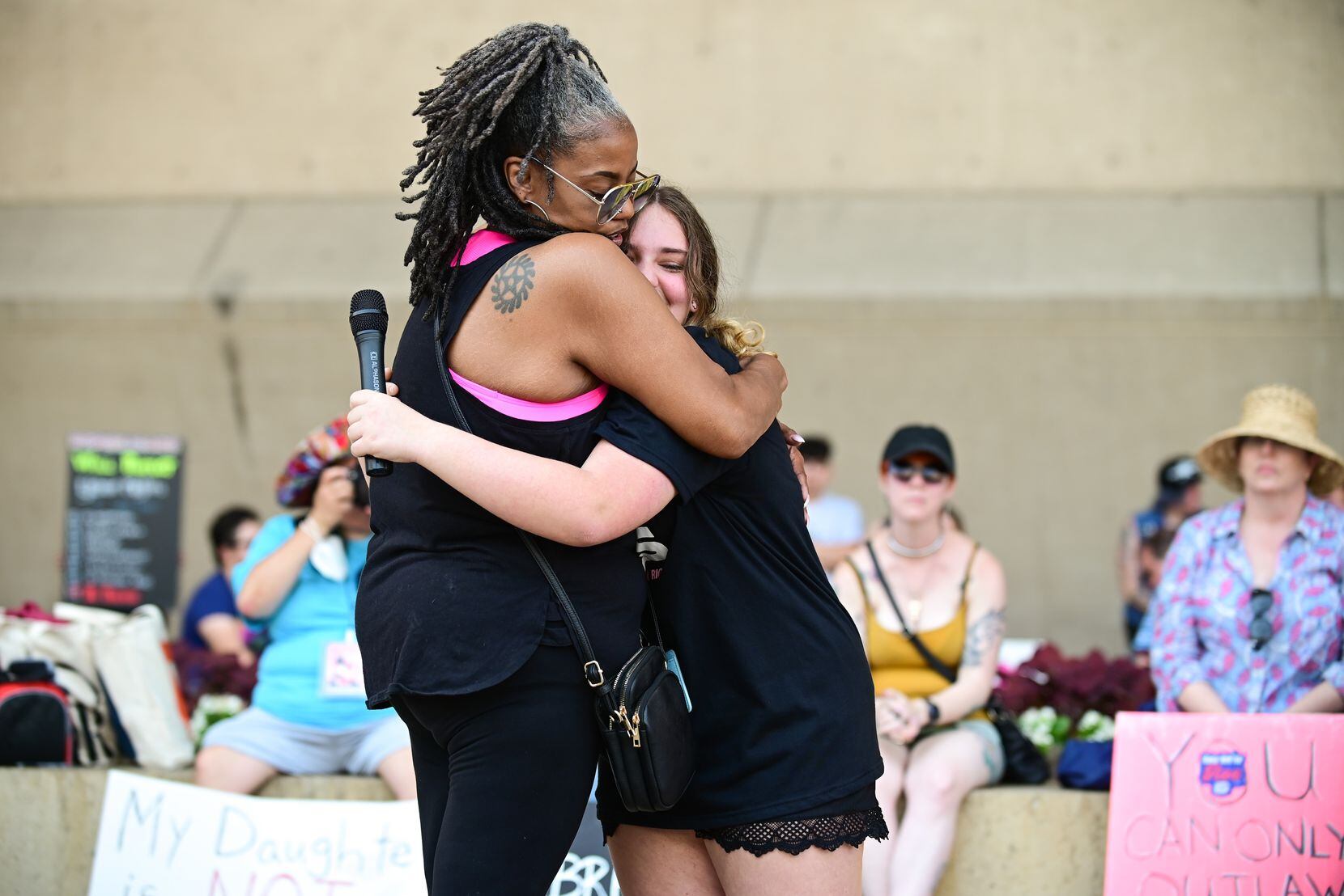Michelle Anderson, with The Afiya Center, hugs Stella Chaney, 13, encouraging her to be...