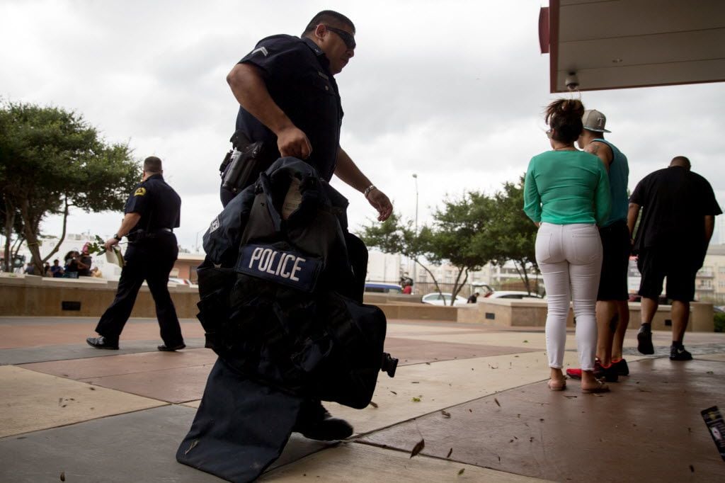 A DPD police officers carry heavy armor into the Dallas Police Headquarters on July 9, 2016...
