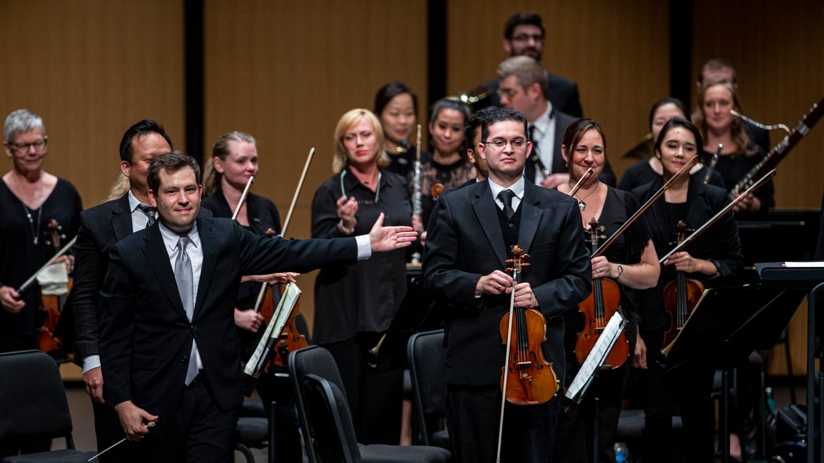 Conductor Richard McKay (left) directs the audiences applause towards violinist Simon Gollo during the season-opening concert by the Dallas Chamber Symphony at Moody Performance Hall in Dallas Oct. 22, 2019.