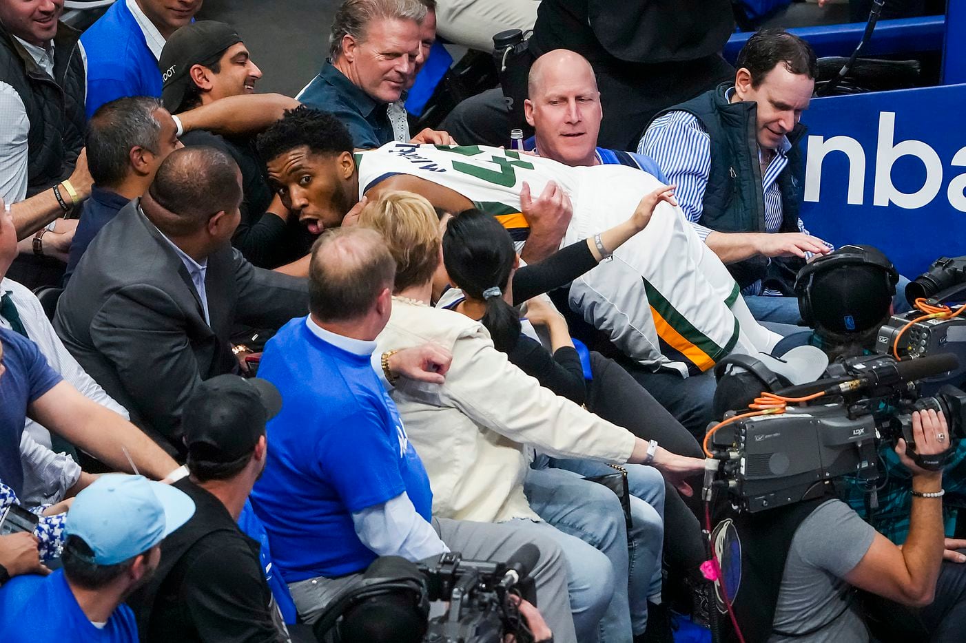 Utah Jazz guard Donovan Mitchell falls into the crowd chasing a loose ball during the first...