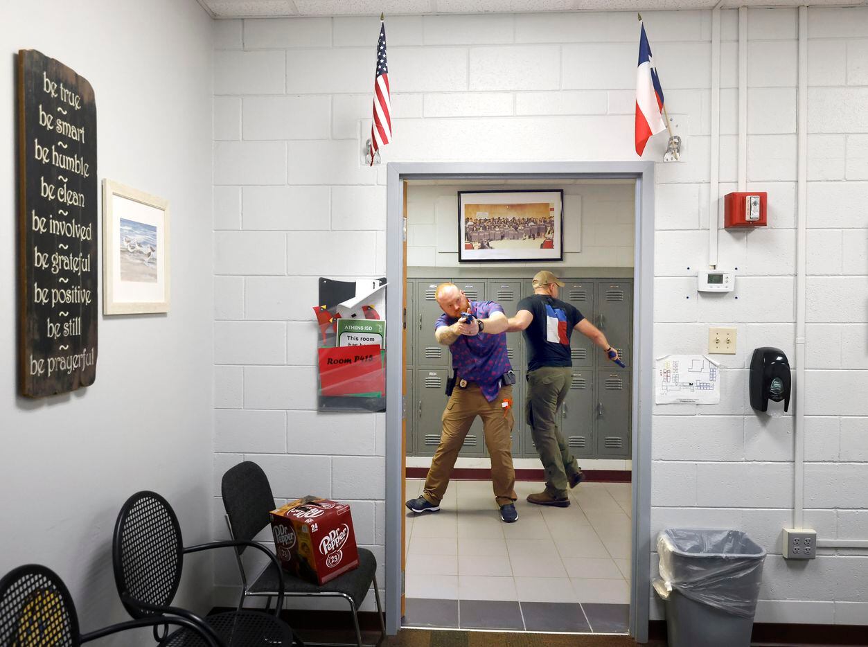 Athens Police Officers Joshua Ames (left) and Zachary Harris approach an open classroom door...