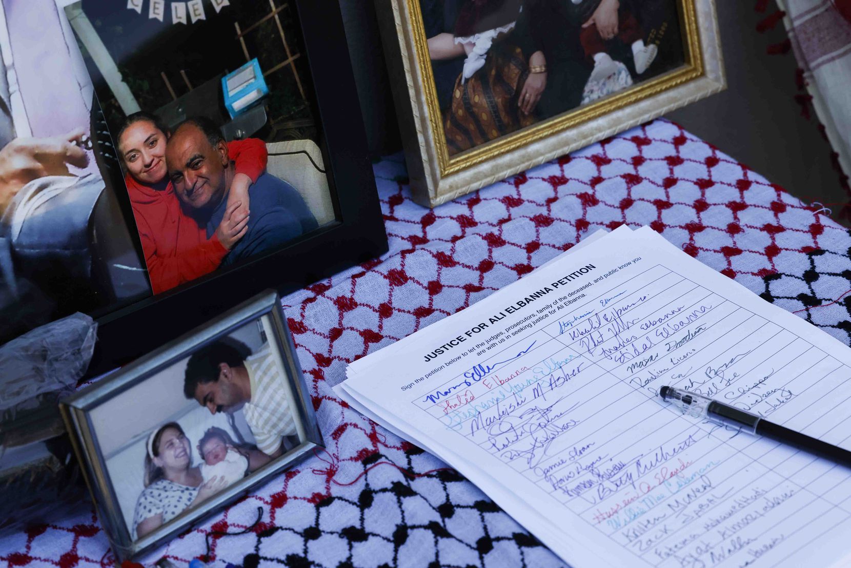 A signed petition sits on a table alongside photos of Ali Elbanna.