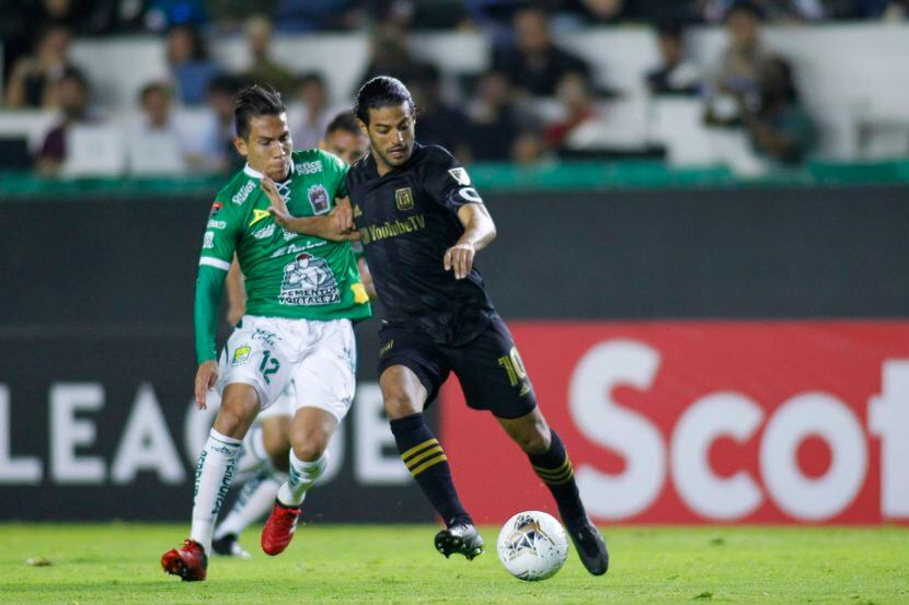 El jugador del LAFC, Carlos Vela (der), protege el balón ante la marca del jugador del León,...