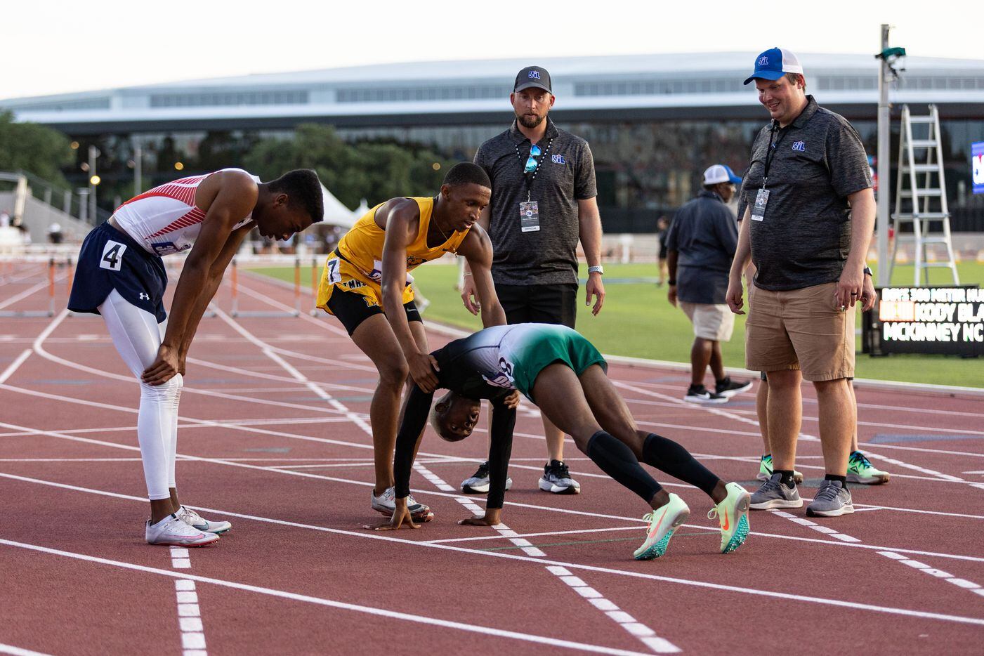 Kendrick Smallwood of Mesquite Poteet is helped up at the finish line after the boys’ 300m...