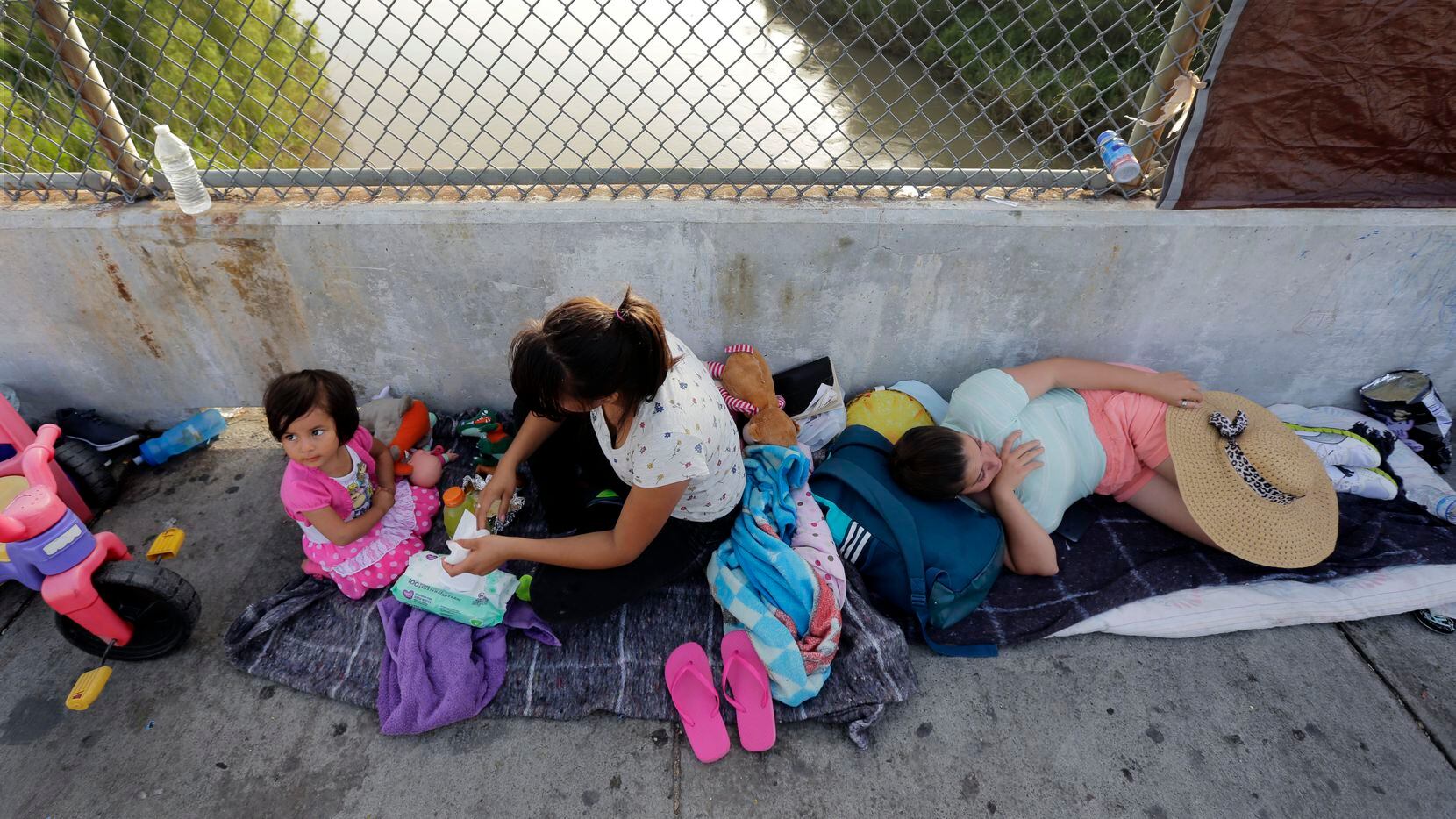 Inmigrantes de Cuba y Guatemala esperan en el puente internacional Rio Grande, al sur de...