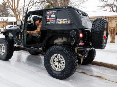 Angel Muniz, Carnales Off Road club member, backs his Jeep up to tow a car stuck on an icy...