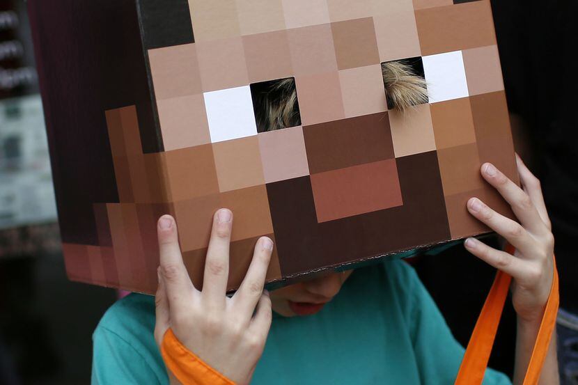 Grayson Young, 7, adjusts his "Steve from Minecraft" mask during "Trick or Treat the Square"...