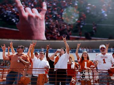Texas Longhorns fans raises their hands with a ‘hook'em horns’ chant during their game...