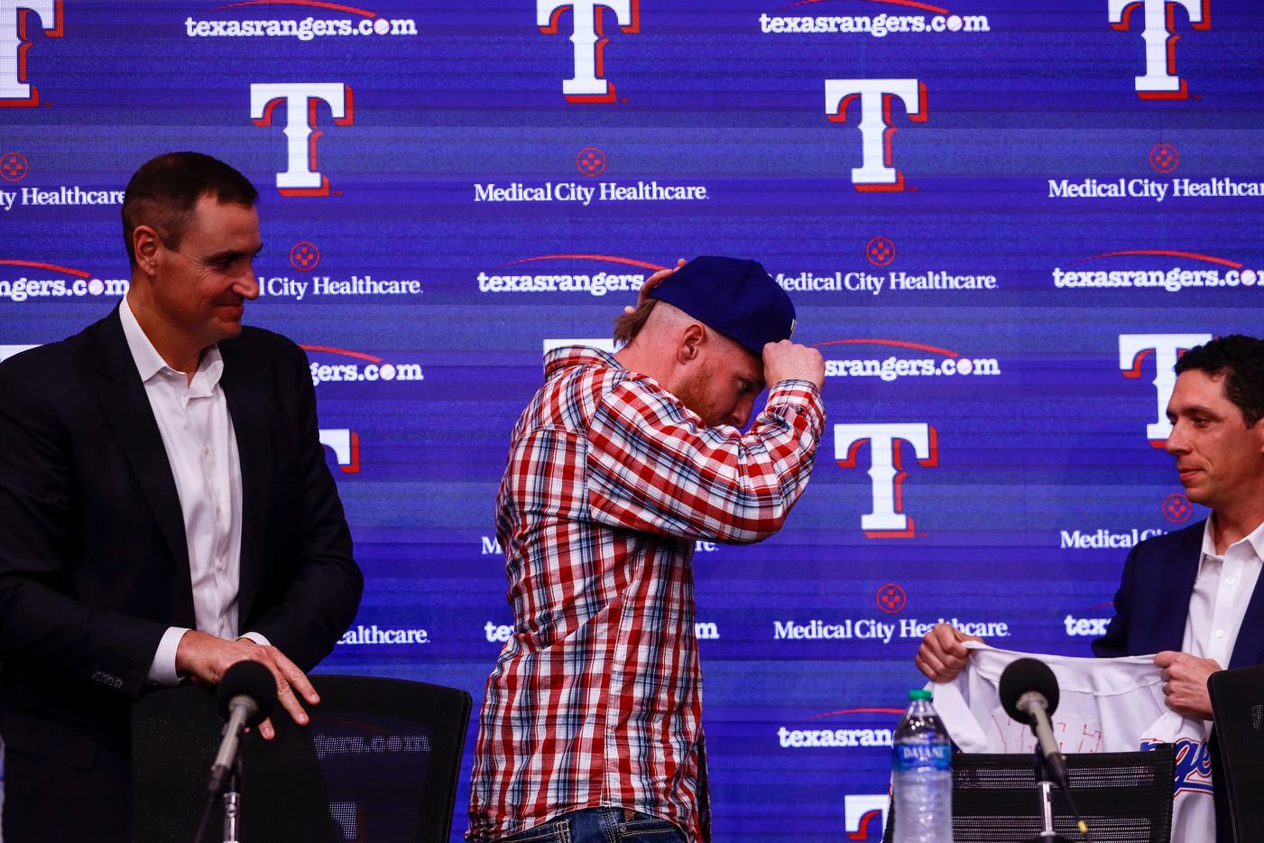 Jon Gray puts on his Texas Rangers' baseball hat at a news conference at Globe Life Park in...