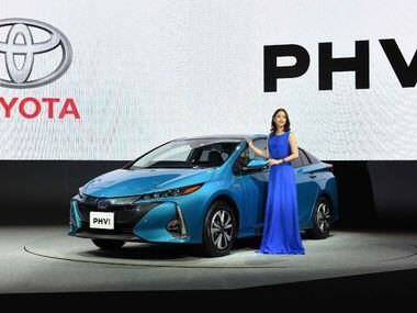 Japanese actress Satomi Ishihara poses beside a redesigned Toyota Motor Prius PHV (plug-in...