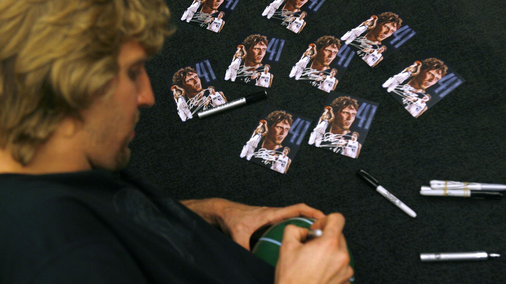 Dirk Nowitzki signs jerseys and paraphernalia for a day with Dirk prize won from a silent...