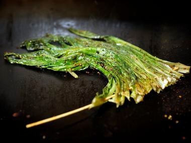 Skwered A-choy (Chinese greens) on a grill at FatNi BBQ (Tom Fox/Staff Photographer)