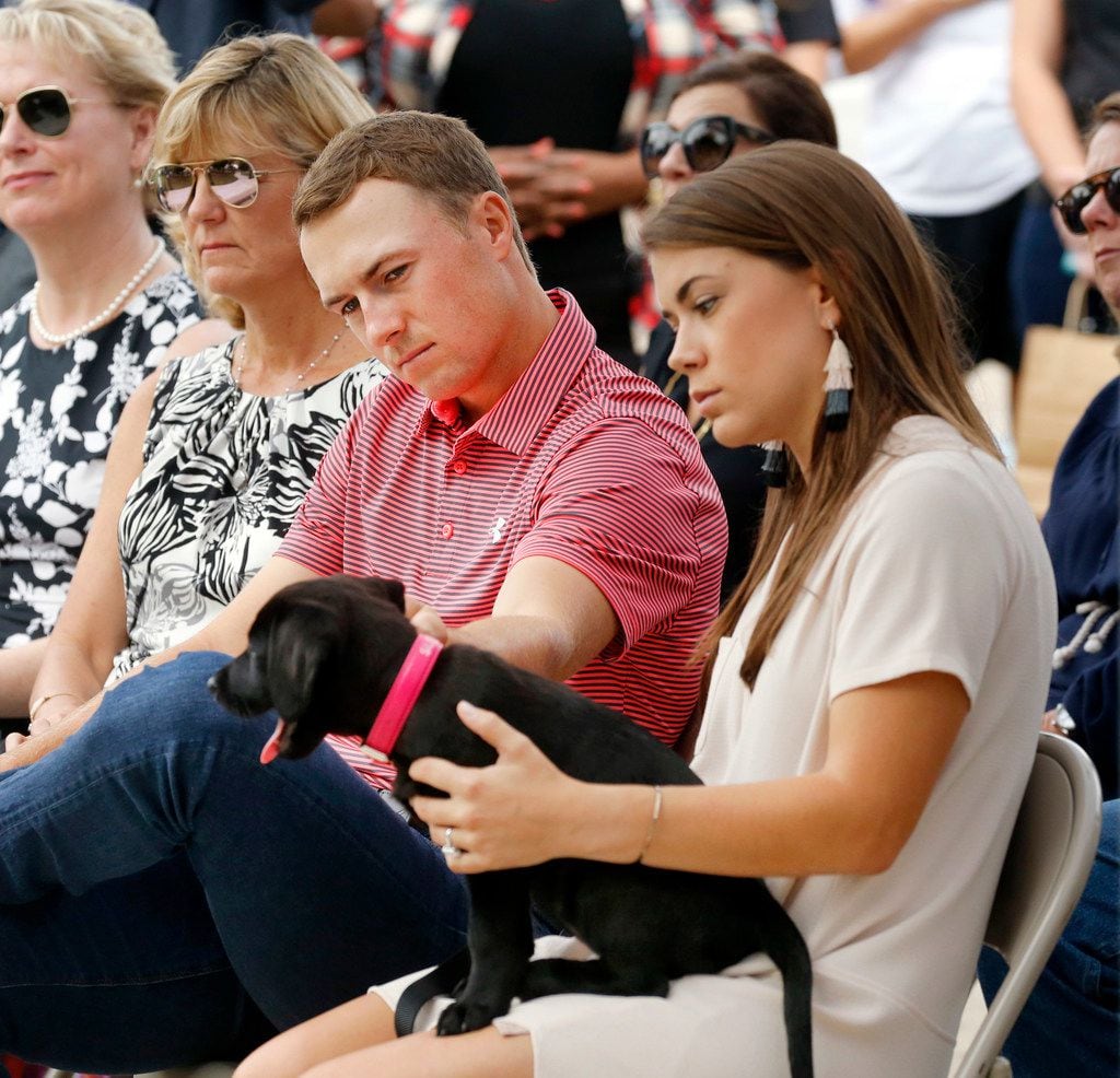 PGA golfer Jordan Spieth plays with he and his fiance Annie Verret's (right) new dog during...