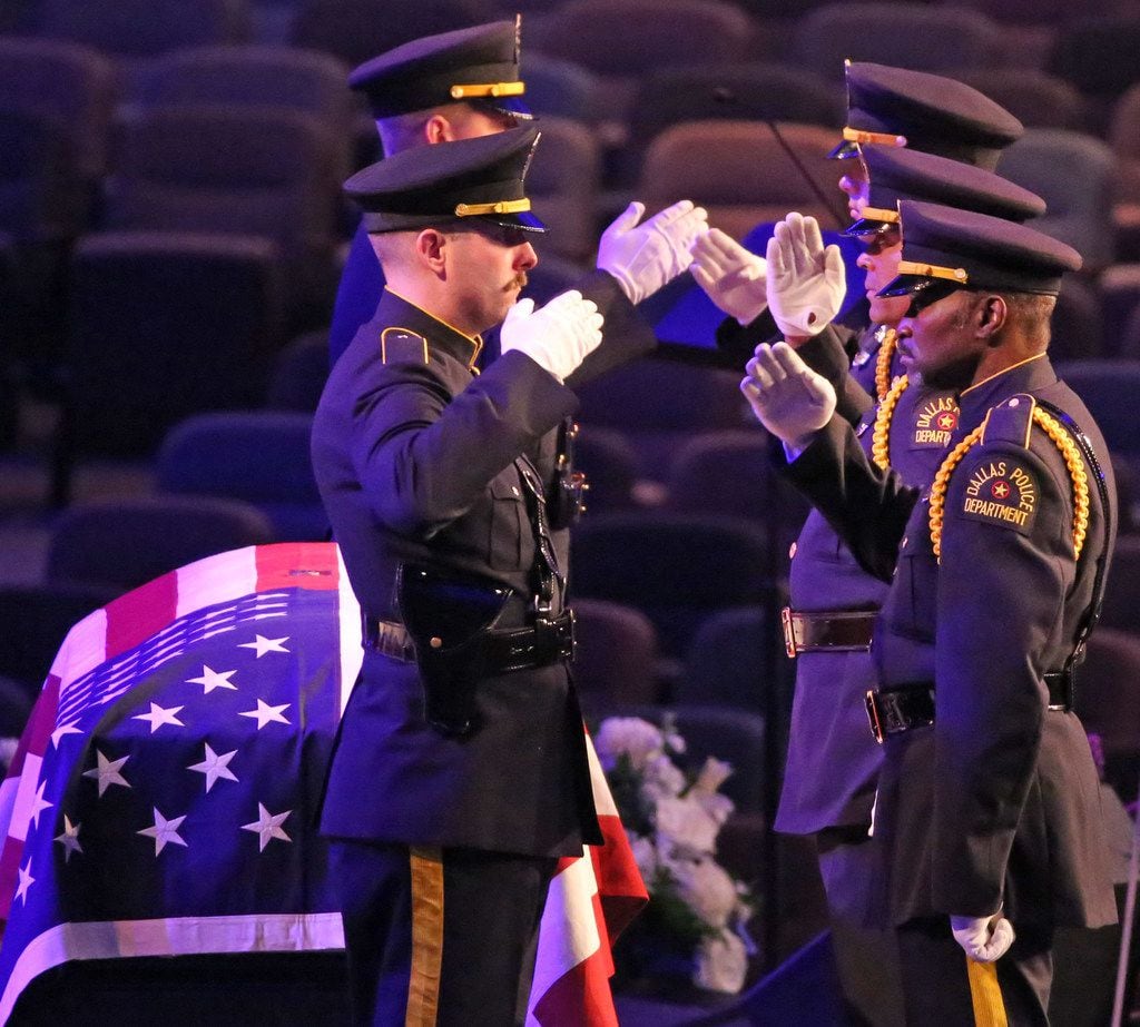 The Dallas Police Honor Guard salutes as they stand watch at the casket at the funeral for...