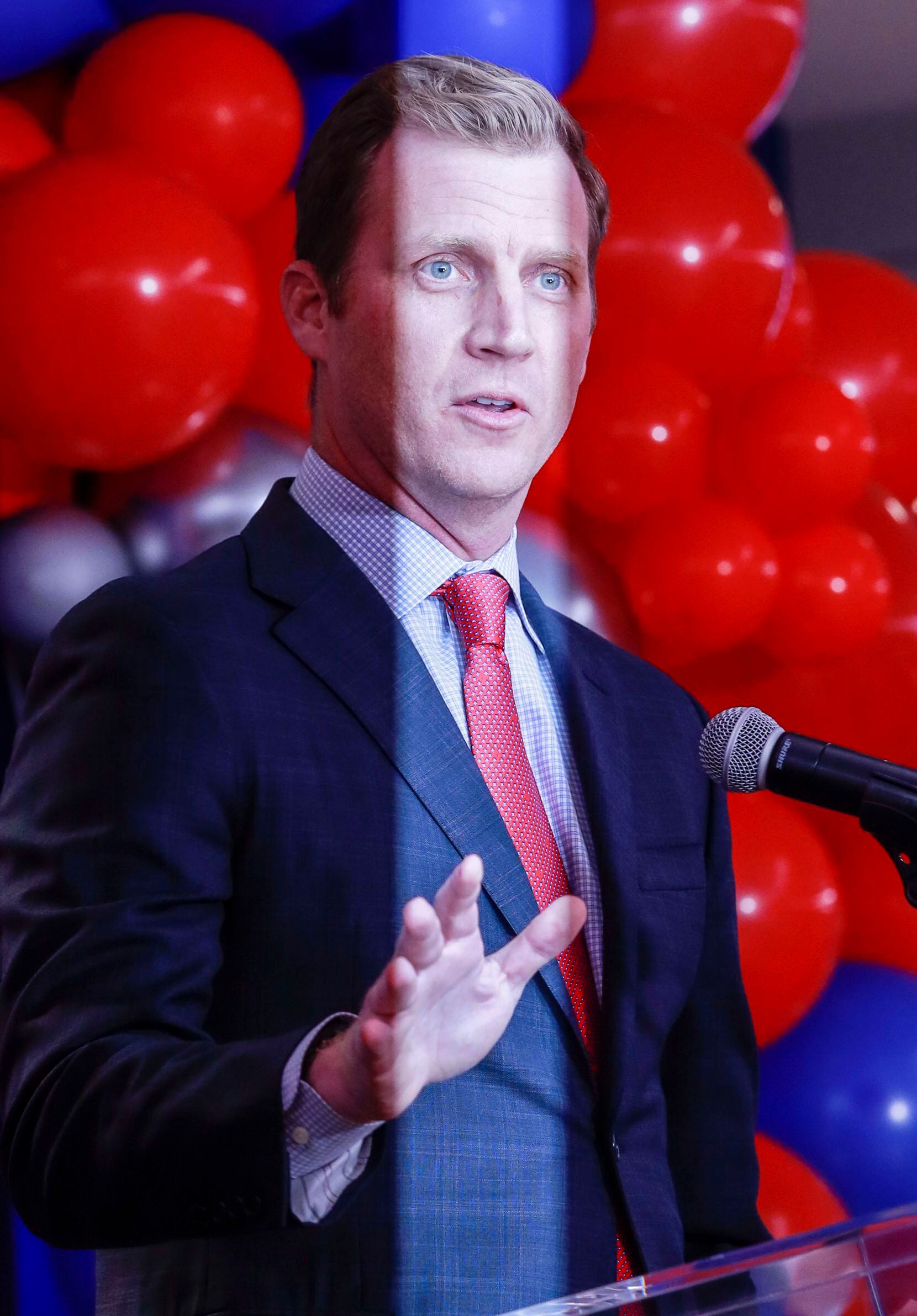 A streak of light from a photographer's flash illuminates Southern Methodist University's head football coach, Rhett Lashlee speaks at a news conference for the first time at Miller Boulevard Ballroom in Dallas on Tuesday, Nov. 30, 2021. Lashlee was Southern Methodist University's former offensive coordinator football coach in 2018 and 2019 before going to the University of Miami for two seasons. (Rebecca Slezak/The Dallas Morning News)