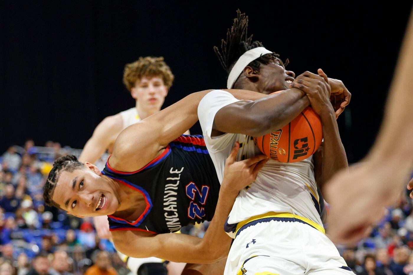 Duncanville forward Davion Sykes (22) and McKinney guard Alex Anamekwe (14) wrestle for the...