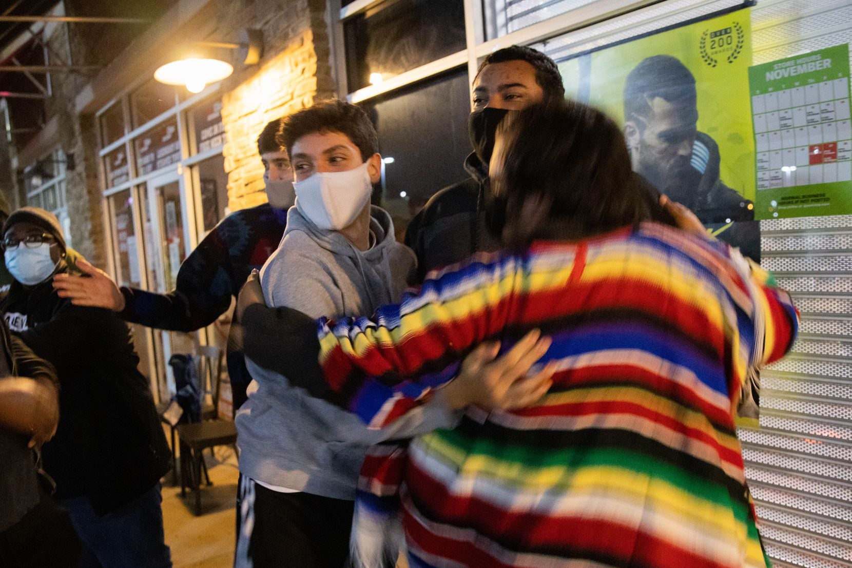 Left to right: George Garrido, Brandon Lopez, and Pedro Collazo hug each other after finding out that the new Xbox and PlayStations are in stock at Timber Creek Crossing GameStop.