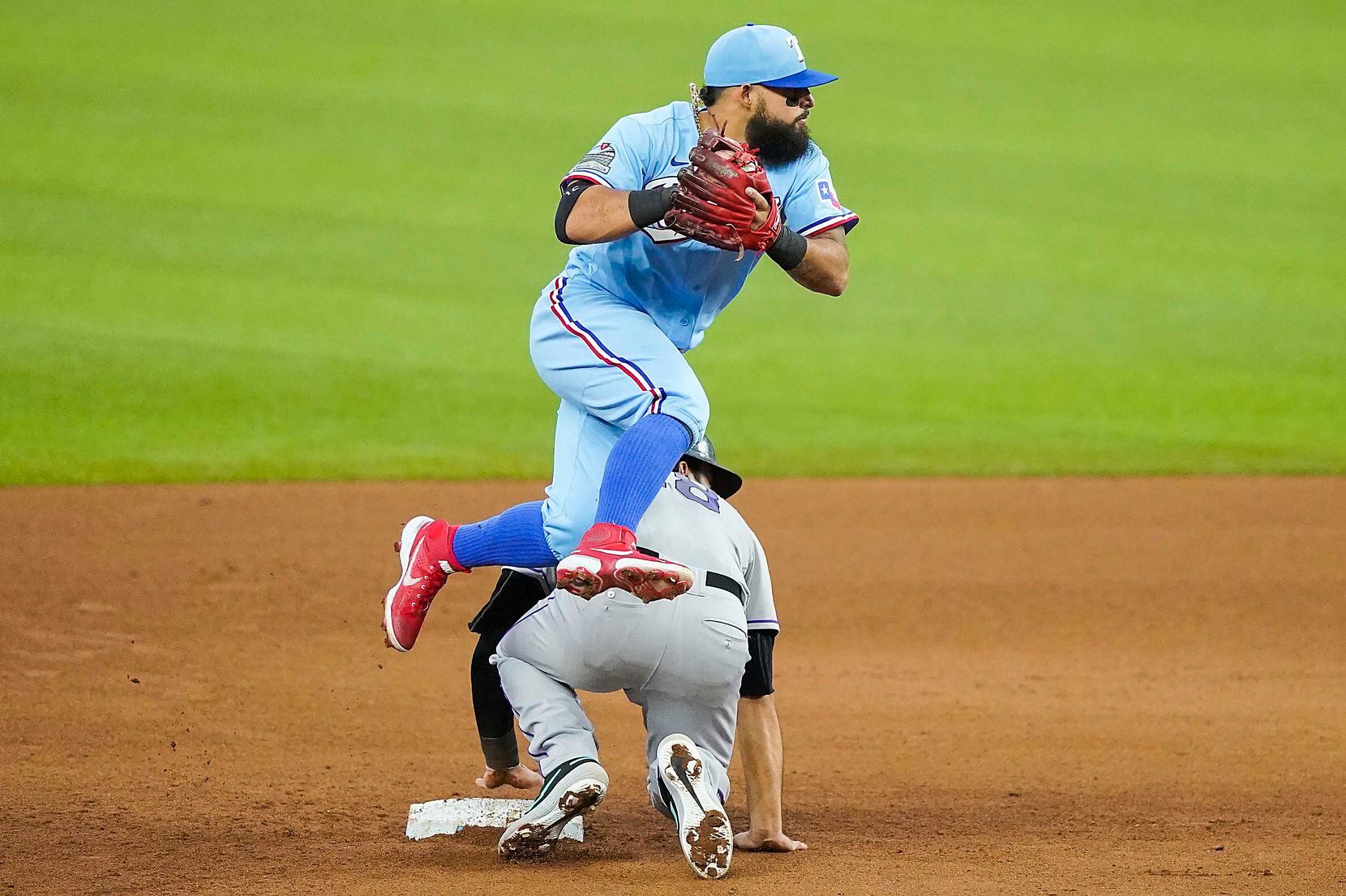 Texas Rangers second baseman Rougned Odor leaps over Colorado Rockies third baseman Nolan...
